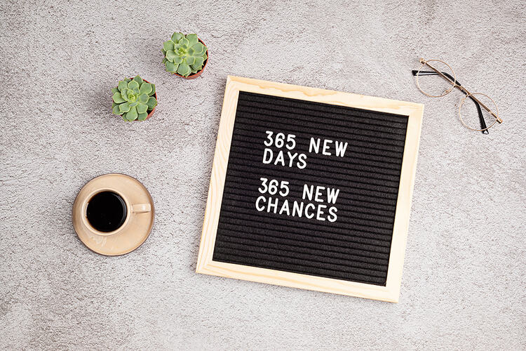 365 new days, 365 new chances. Letter board with motivational self-improvement quote on concrete background with a coffee cup and two small cacti. New year resolutions, motivation, goal setting